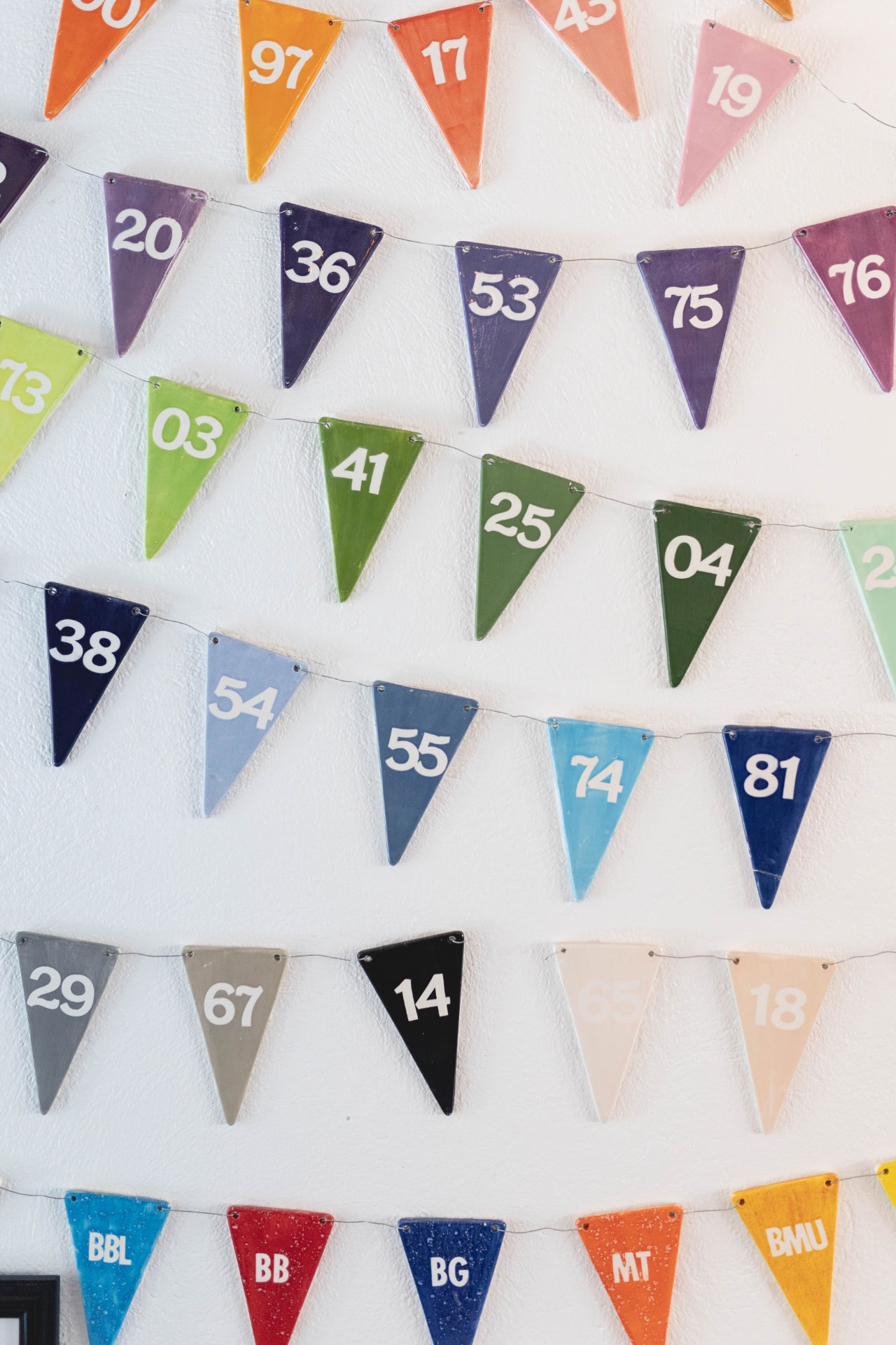 Hand-glazed color sample pennants on the shop wall